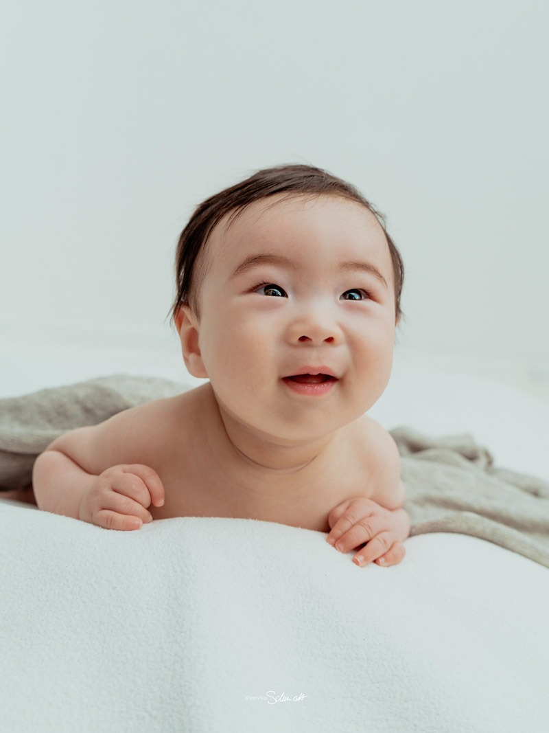 Babyshooting Hannover mit einem lächelnden Neugeborenen hell und freundlich portraitiert von KreativNus Schmidt Fotografie