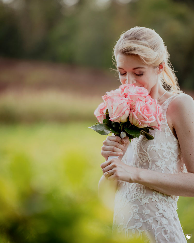 Hochzeitsfotografie in Hannover mit KreativNus Schmidt Fotografie - Braut riecht verträumt an Brautstrauß 