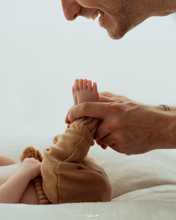Detailaufnahme Babyfüße in Elternhänden - Familienfotografie Hannover KreativNus Schmidt Fotografie. Emotionale Detailaufnahme aus der Neugeborenenfotografie in der Region Hannover. Zarte Babyfüße in den Händen der Eltern als Symbol für Nähe und Geborgenheit.